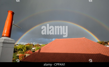 Double rainbow over British suburban rooftops Stock Photo