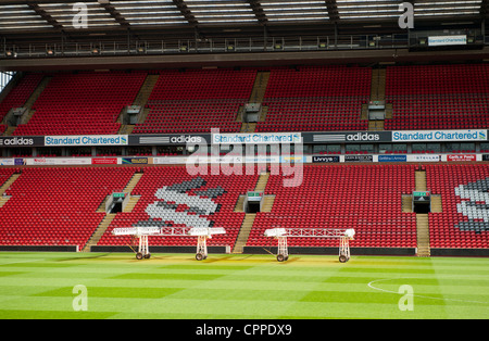 Stands and pitch at Anfield when empty. Set of lights are on pitch to encourage grass growth. Stock Photo