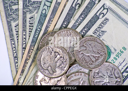 Small pile of small American bills and old silver half dollars Stock Photo