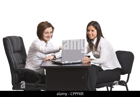 Two young businesswoman working together on a laptop at their office desk. Stock Photo