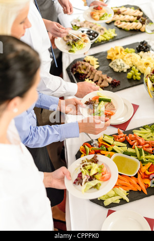 Business people around buffet table catering food at company event Stock Photo