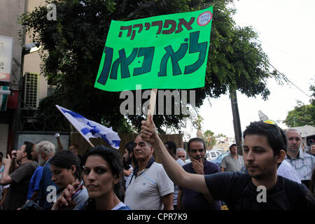 An Israeli protester holds a paperboard sign in Hebrew which reads 'Africa is not Here' during demonstration against African asylum seekers and illegal immigrants in southern Tel Aviv Israel Stock Photo