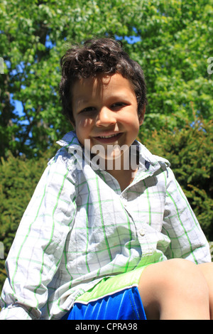 Cute little five year old boy portrait with green nature background Stock Photo