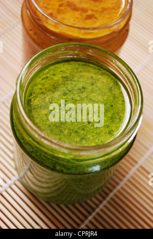 Fresh basil pesto and tomatoes sauce, typical italian dressing for pasta Stock Photo