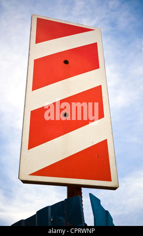 Vertical red white stripped road sign on the corner of construction area Stock Photo