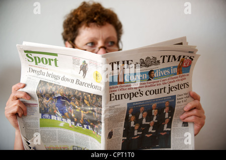 Woman reading a copy of The Times (UK) newspaper Stock Photo