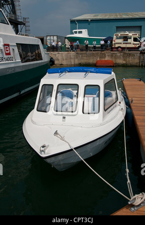 Small fibre glass open boat tied up in port. Stock Photo