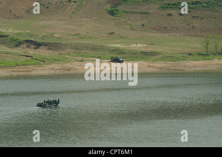 JI'AN, JILIN, CHINA; 20/05/2012. A North Korean patrol boat loaded with oil drums is crossing the Yalu river from China Stock Photo