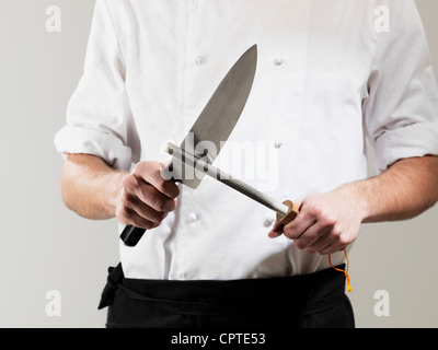 Professional chef knife, peeling knife and sharpening steel on wood cutting  board over a kitchen table. Chef working tools. Modern kitchen utensils  Stock Photo - Alamy