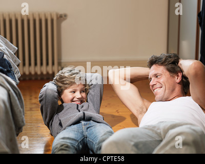 Mature man and son performing exercises in bedroom