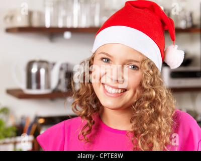 Portrait of young woman wearing Santa hat, smiling Stock Photo