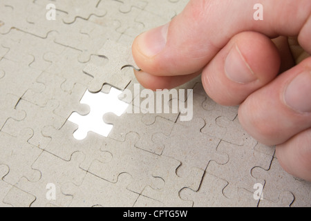puzzle piece coming down into it's place Stock Photo