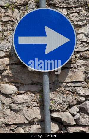 A road sign pointing the direction up a mountain road in Lake Garda Malcesine Italy Stock Photo