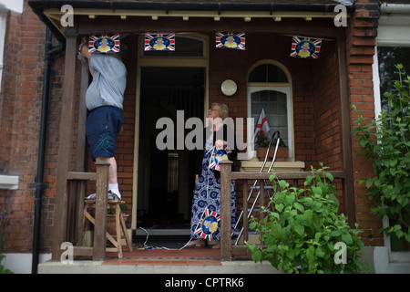 A London couple hang royal bunting the day before Queen Elizabeth's Diamond Jubilee celebrations in the porch of their south London home ahead of a weekend of nationwide celebrations for the monarch's Diamond Jubilee. Stock Photo