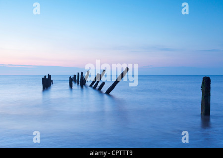 Old sea defences at dawn, smooth water from long exposure. Stock Photo