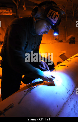 Aviation Machinist's Mate 3rd Class Justin Neist, assigned to the Wildcats of Strike Fighter Squadron (VFA) 131, performs maintenance on F/A 18C Hornet in the hangar bay aboard the Nimitz-class aircraft carrier USS Dwight D. Eisenhower (CVN 69). Dwight D. Eisenhower, the flagship for Carrier Strike Group 8, is under way conducting a composite training unit exercise (COMPTUEX) in the Atlantic Ocean. Stock Photo