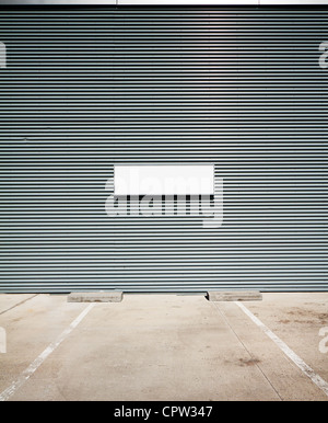 Concrete parking floor and tin wall with blank info board. Stock Photo
