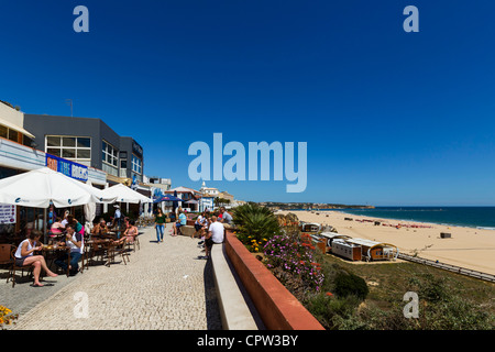 Bars and cafes on seafront promenade overlooking main beach in  centre of resort of Praia da Rocha, Portimao, Algarve, Portugal Stock Photo