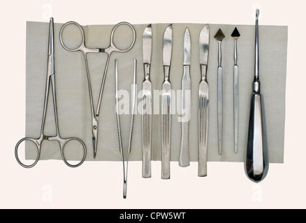 Scalpels and a set of different surgical instruments on a napkin and a white background Stock Photo