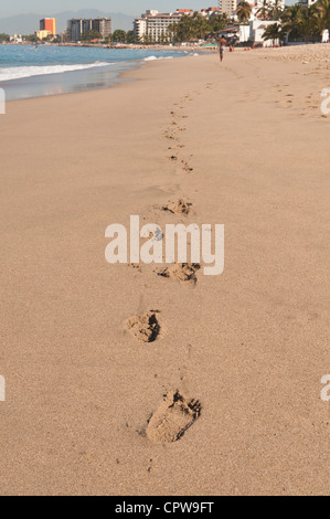 Footprints footsteps in sand on Playa Los Muertos coastline beach, Puerto Vallarta, Mexico.