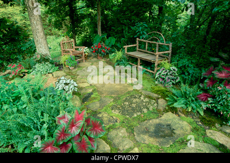 Shade garden with handmade rustic furniture and colorful caladium plants, Missouri USA Stock Photo