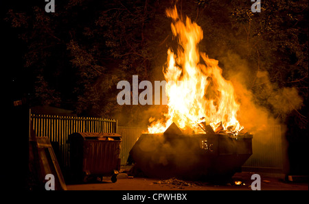 Fire in the city night: burning trash container Stock Photo