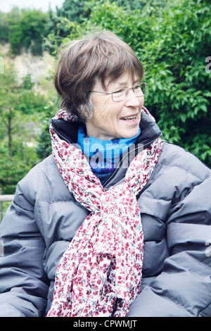 Senior woman wearing scarf and winter coat, outdoors. Stock Photo