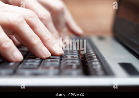 Senior woman typing on laptop close up. Stock Photo
