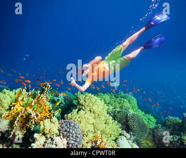Happy man swimming underwater and talking by pone Stock Photo
