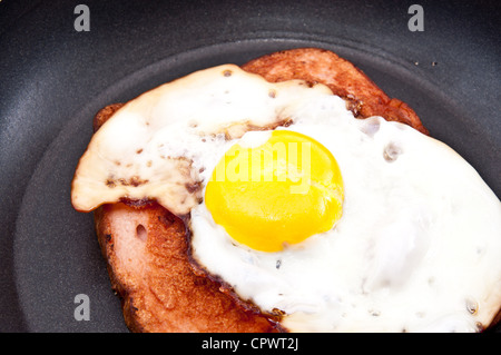 Fried egg with meat in a skillet isolated on white background Stock Photo