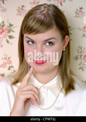 An attractive young woman looking up and thinking about something. Stock Photo