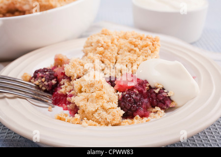 Home baked blackberry and apple crumble with a dollop of Greek yoghurt. Making the most of juicy autumn fruits. Stock Photo