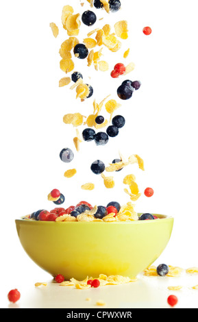Flying to the bowl corn flakes with berries isolate on white Stock Photo