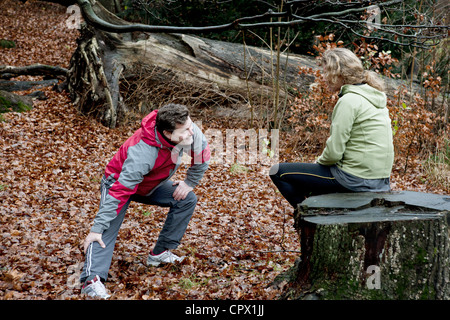 Mature couple performing warming up exercises in forest Stock Photo