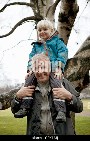 Boy sitting on grandfathers shoulders, portrait Stock Photo