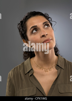 Mid adult woman looking up, studio shot Stock Photo