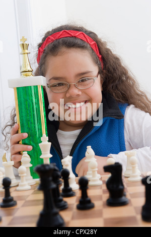 Portrait of young girl holding chess trophy Stock Photo