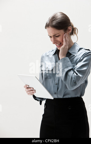 Young businesswoman using digital tablet, studio shot Stock Photo