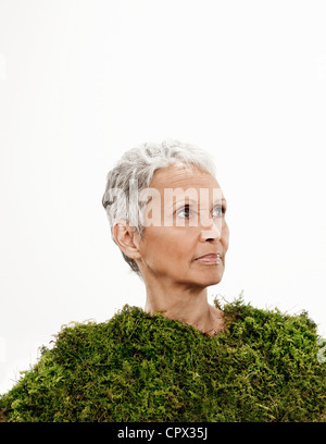 Senior woman wrapped in moss Stock Photo