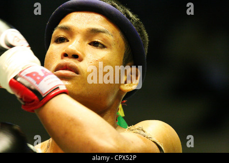 A boxer concentrates on pre-fight rituals at the Rajadamnern Stadium in Bangkok, Thailand. Stock Photo