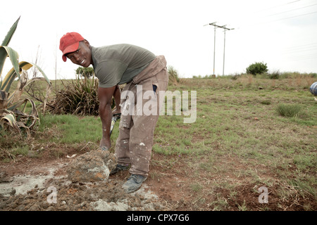 Young black construction worker digging into the ground Stock Photo