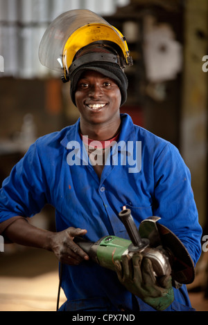 Worker posing with grinder in magnet factory, Gauteng, South Africa Stock Photo