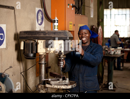 Factory worker operating drill press in magnet factory, Gauteng, South Africa Stock Photo