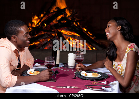 An African couple having dinner outdoors next to a fire Stock Photo