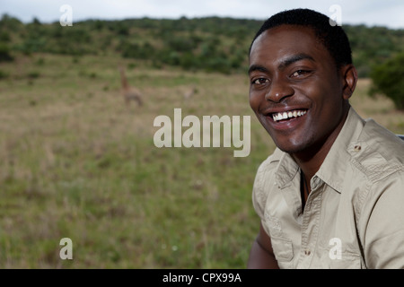 An African man sitting outside and smiling towards the camera Stock Photo