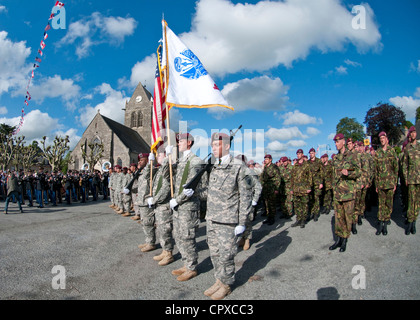 Task Force 68, which is made up of paratroopers from U.S., Germany, France, Holland, and United Kingdom, re-enacted the D-Day airborne operation on the La Fiere fields near Ste. Mere Eglise, France to commemorate the heroic acts of the WWII paratroopers who made the jump 68 years ago. After the jump, the task force marched into the town of Ste. Mere Eglise tothe sounds of cheers from the locals. Task Force 68 is in Normandy, France to commemorate the 68th annivesary of D-Day. Stock Photo