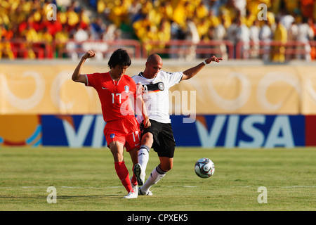 Suk Young Yun of South Korea (L) passes the ball ahead of Dani Schahin of Germany (R) during a FIFA U-20 World Cup match. Stock Photo