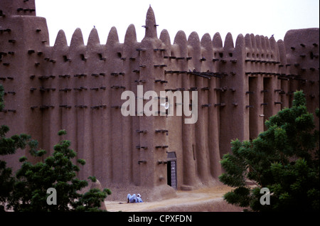 Mali Mopti Region Djenne listed as World Heritage by UNESCO a man resting under Great Mosque (biggest mud brick mosque in world) Stock Photo