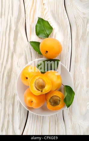 Apricots on the plate on a wooden background Stock Photo