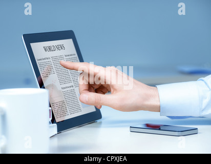 Businessman pointing on modern digital tablet with world news on screen at the workplace. Stock Photo